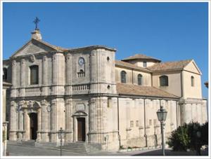 duży kamienny budynek z zegarem w obiekcie Borgo Medievale Squillace w mieście Squillace