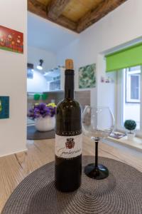 una botella de vino y una copa de vino en una mesa en Guest House Blue, en Zadar