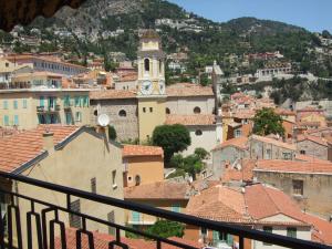 a view of a town with a clock tower at The Dina Palace. in Villefranche-sur-Mer