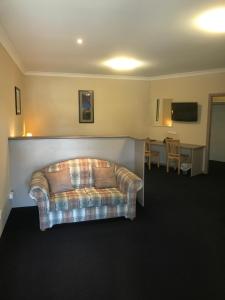 
a living room with a couch and a table at The Bakehouse Motel in Goulburn
