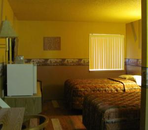 a hotel room with two beds and a window at Earth Inn Motel - Jackson in Jackson