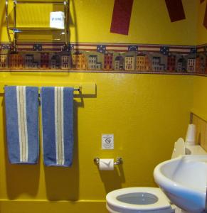 a yellow bathroom with a toilet and a sink at Earth Inn Motel - Jackson in Jackson +40 photos