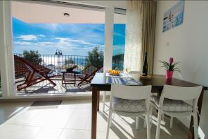 a dining room with a table and chairs and a balcony at Apartment Primosten Adiomare in Primo&scaron;ten
