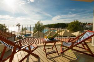 a patio with two chairs and a table on a balcony at Apartment Primosten Adiomare in Primošten
