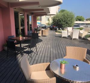 a patio with tables and chairs on a deck at Hotel Flamingo in Rimini