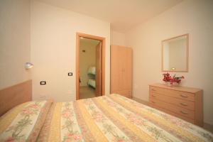 Schlafzimmer mit einem Bett, einer Kommode und einem Spiegel in der Unterkunft Residence San Luca Vieste in Vieste