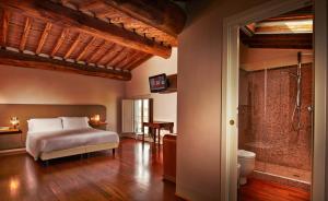 Un dormitorio con una cama y un baño con ducha. en Cascina Canova, en San Giuliano Terme