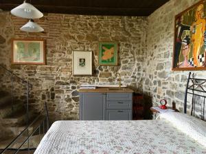 a bedroom with a bed and a stone wall at Nittardi in Castellina in Chianti