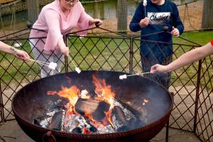 a group of people standing around a grill at Tattershall Lakes Country Park in Tattershall +16 photos