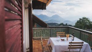 einen Tisch mit einer Flasche Wein und Stühlen auf dem Balkon in der Unterkunft Ferienwohnung Morgengabe in Fraxern