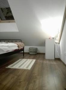 1 dormitorio con 1 cama y suelo de madera en Sky view Condo in Tarnowskie Góry en Tarnowskie Góry