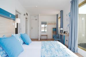 a bedroom with a bed, a desk, and a window at Hotel Salou Beach by Pierre & Vacances in Salou