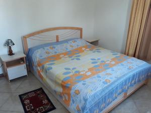 a bedroom with a bed with a blue comforter at Trochetia villa in Pereybere