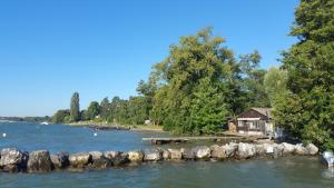 a cottage on the shore of a lake with a dock at BnB "Les Coquelicots" in Mies