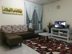 a living room with a couch and a tv at A1-04-03 Damiana Apartment in Tanjung Malim