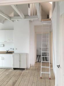 een ladder in een lege kamer met een keuken bij Beautiful apartment in a historic villa in Hattingen