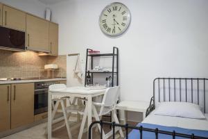 a kitchen with a table and a clock on the wall at Nektarios Garenias Kipoupoli in Nea Kalikratia