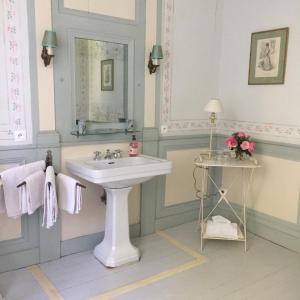een witte badkamer met een wastafel en een spiegel bij Chateau de Juvigny in Juvigny-sur-Marne