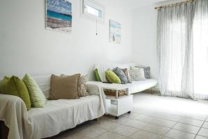 a living room with a couch with pillows on it at Nektarios Garenias Kipoupoli in Nea Kalikratia