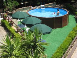 a pool with umbrellas and people swimming in it at Residence San Antonio in Marina di Camerota