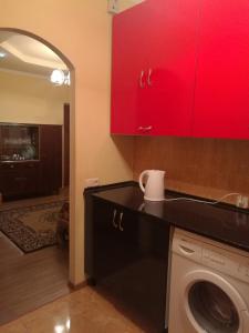 eine Küche mit roten Schränken und einer Waschmaschine in der Unterkunft Jermuk Apartment in Dschermuk