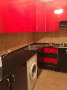 a kitchen with red cabinets and a washing machine at Jermuk Apartment in Jermuk