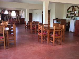 a dining room filled with tables and chairs at Skyway Hotel in Entebbe