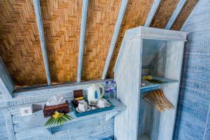 a small bathroom with a shelf with a tea kettle at D'Yuki Huts Lembongan in Nusa Lembongan