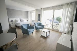 バイヨンヌにあるParc 709 Bayonneのベッド、椅子、テーブルが備わるホテルルームです。