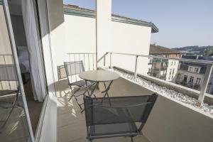 a balcony with a table and chairs and a window at Parc 709 Bayonne in Bayonne