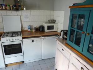 a kitchen with white appliances and a blue cabinet at 404-Hostel in Cologne