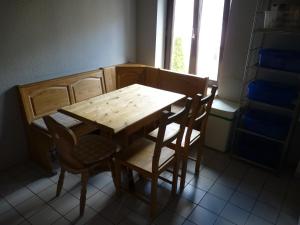einen Holztisch und Stühle in einem Zimmer mit Fenster in der Unterkunft 404-Hostel in Köln