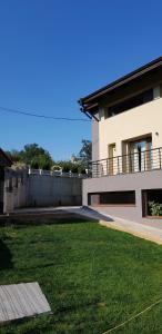 a house with a grass yard in front of it at Mihaylova kushta in Lyubosh