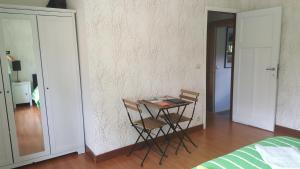 a table and chairs in a room with a bedroom at Au calme in Marchin