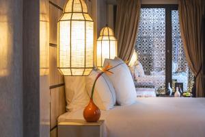 ein Schlafzimmer mit einem Bett mit einer Lampe und einem Fenster in der Unterkunft Dar Kandi in Marrakesch