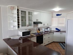 una cocina con armarios blancos y microondas en una encimera en Strand Beach Front, en Strand