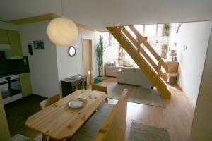 a living room with a wooden table and a kitchen at I dr Rehwiesa A32 in Arosa