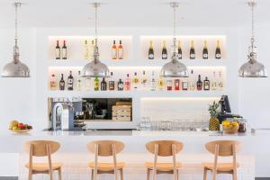 a kitchen with a bar with chairs and bottles at Laguna - Vilamoura in Vilamoura