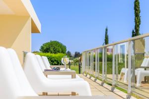 a row of white chairs and a table on a balcony at Laguna - Vilamoura in Vilamoura
