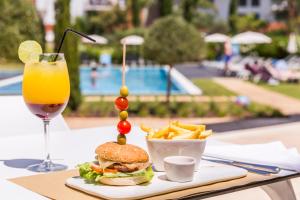 a sandwich and french fries and a drink on a table at Laguna - Vilamoura in Vilamoura