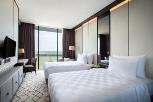 Postel nebo postele na pokoji v ubytování Wyndham Opi Hotel Palembang