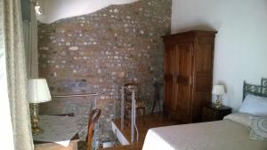 a bedroom with a brick wall and a bed at Antica Scuderia in Buttrio