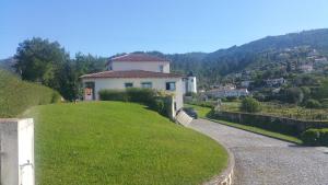 a house on top of a grassy hill at Casa Estrada da Guia in Viana do Castelo