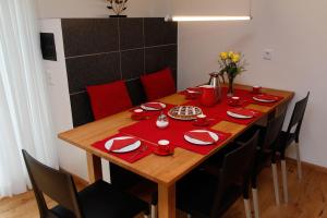 a dining room table with red napkins and chairs at Chalet Alpenrose 134qm am Golfplatz Oberstaufen in Oberstaufen +20 photos