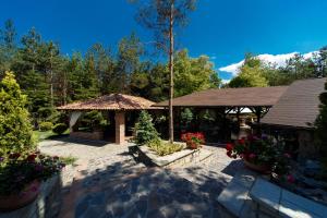 a patio with a gazebo and some flowers at Hotel Helen in Bacău