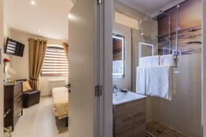 a bathroom with a sink and a mirror at Suites By The River in Ferragudo