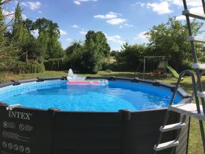 een zwembad in een tuin met een speeltuin bij Les Trois Piliers in Saint-Clair