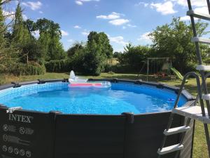 a swimming pool in a yard with a playground at Les Trois Piliers in Saint-Clair