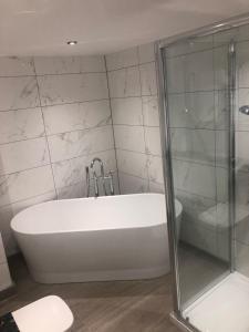 a white bath tub in a bathroom with a shower at Riverside Lodge Hotel in Irvine