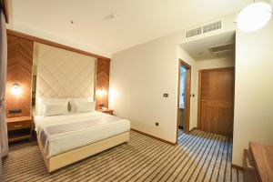 a hotel room with a bed and a door at Hotel Union in Podgorica